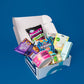 An open Dorm Drop box on a blue background, packed with snacks, a power bank, toothpaste and dorm toiletries